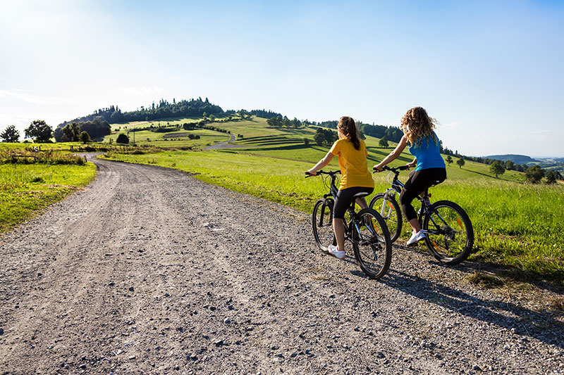 Young women biking on a trail